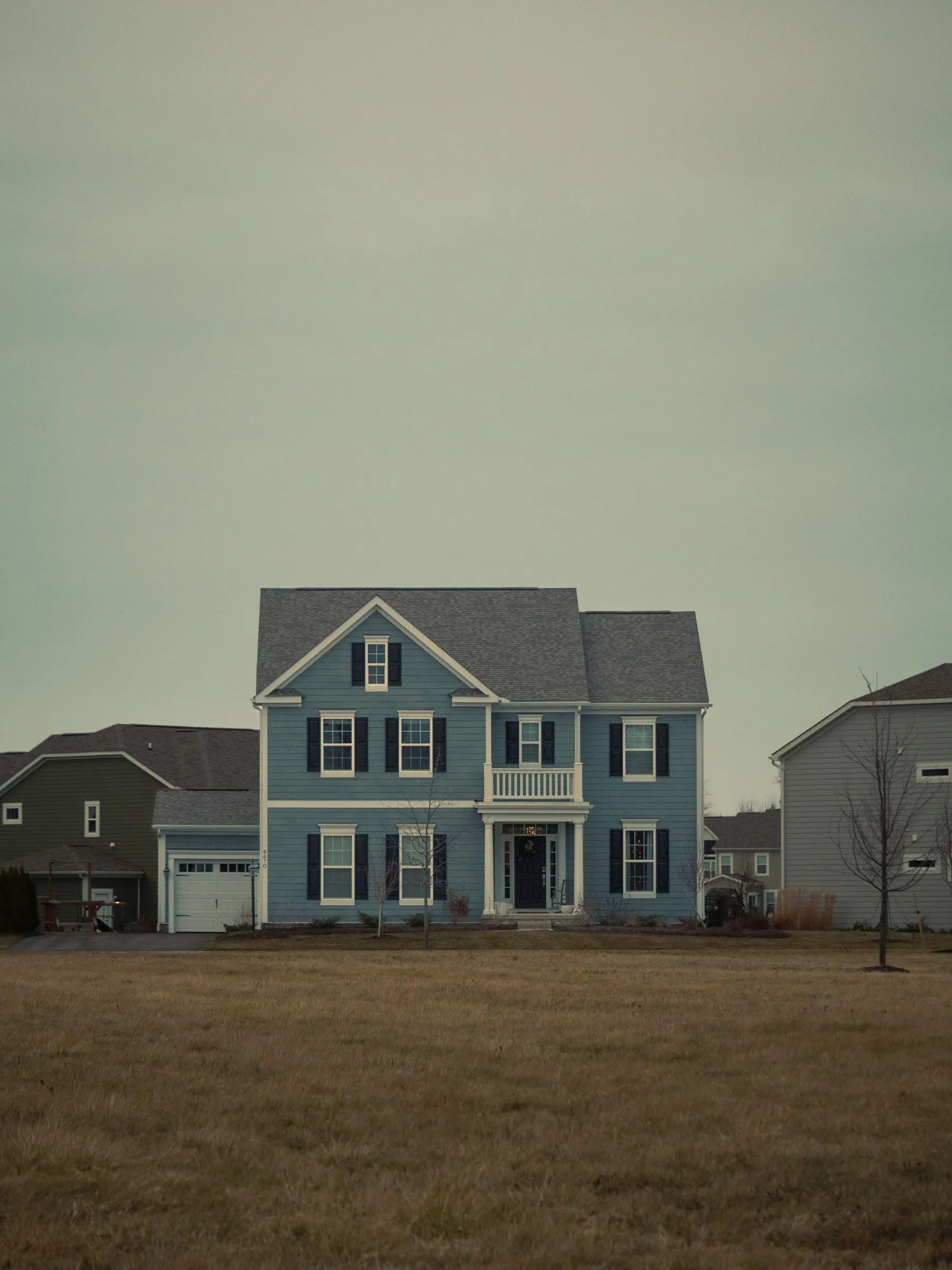 Blue two-storey house with a grey shingle roof